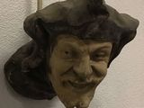 a statue of a man with a hat on a wall