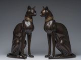 two bronze statues of a cat and a dog sitting next to each other