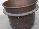 a large metal pot sitting on a cement floor