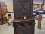 a tall wooden cabinet that is in the middle of a room