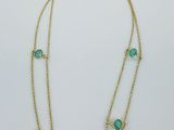un collier en or orné de perles de verre vertes et d'une chaîne en or