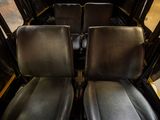 two seats in the back of a bus that are empty