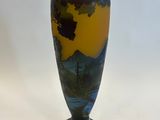 a vase that is sitting on a stand on a white surface