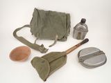 a bag, a spoon, a bottle, and a brush on a white surface