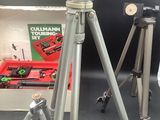 a silver tripod sitting next to a box with a camera on it