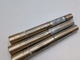 three pens sitting on top of a white table next to each other