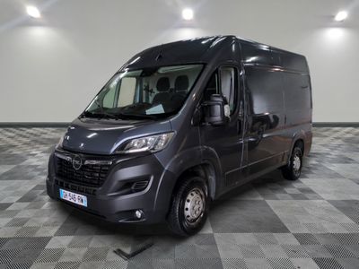 La camionnette grise est garée dans une grande pièce au sol à carreaux.