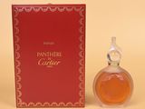 l'image d'un flacon de parfum posé à côté d'une boîte