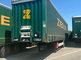 two green semi trucks that are parked next to each other