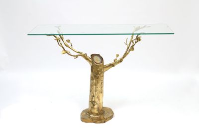 a glass table with a gold tree on it