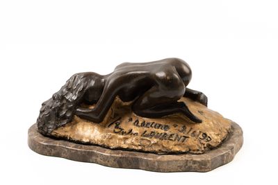 statue en bronze représentant une femme allongée sur un rocher, la tête baissée