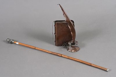 une image représentant un stylo et un livre sur lequel est posée une plume