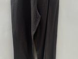 a black pants hanging on a hanger on a white wall