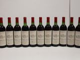 six bottles of red wine lined up in a row on a table