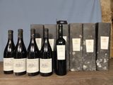 several bottles of wine are lined up on a wooden table