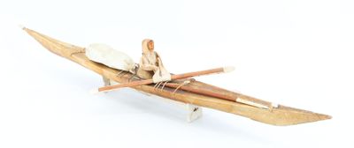 un petit bateau en bois avec deux personnes à bord