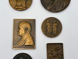 a group of five bronze plaques of a man and a woman
