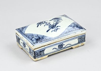une petite boîte bleue et blanche posée sur une surface blanche