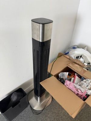 un purificateur d'air noir et argenté à côté d'un carton