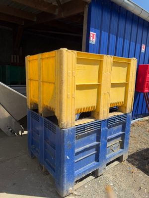 une caisse bleue et jaune posée devant un bâtiment bleu