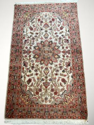 un tapis persan antique avec un motif floral sur fond blanc