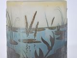 a glass vase with a picture of a pond and reeds