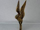 une statue en or représentant un oiseau avec des ailes sur la tête