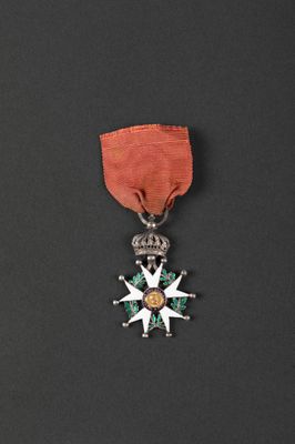 a close up of a medal on a black surface with a red ribbon
