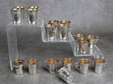 plusieurs coupes en argent et des plateaux de couverts en argent posés sur une table