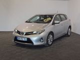 La Toyota Corolla argentée est garée dans une pièce au sol carrelé en damier.