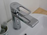 a white bathroom sink with a chrome faucet and soap dispenser