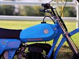 a blue motorcycle parked in front of a white fence