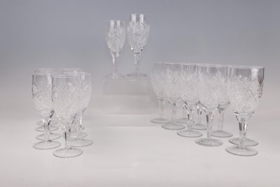 Plusieurs verres à vin transparents sont alignés sur une surface blanche
