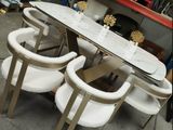 une table blanche entourée de quatre chaises dans une pièce