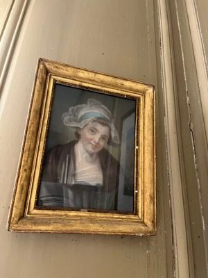 une photo d'une femme coiffée d'un chapeau, accrochée au mur