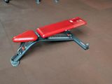 a red bench sitting on the floor in a gym