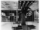 photographie en noir et blanc représentant une sculpture d'un homme dans une pièce remplie de miroirs