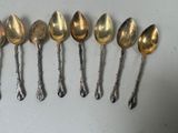 six silver spoons are lined up in a row on a table