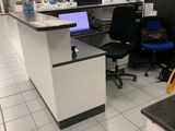 un bureau d'ordinateur sur lequel est posé un ordinateur portable, dans une bibliothèque