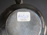 a close up of a silver vase with a sticker on it