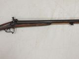 un fusil accroché au mur, muni d'une crosse en bois