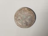 a close up of a silver coin on a white surface