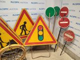 three road signs and a wheelbarrow in a room