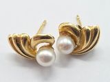 pair of pearl and gold earrings on a white surface