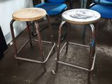 three blue chairs and two stools in a room