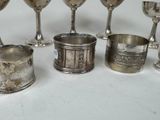 several silver cups and spoons are lined up on a table