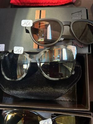Plusieurs paires de lunettes de soleil sont exposées dans une vitrine.
