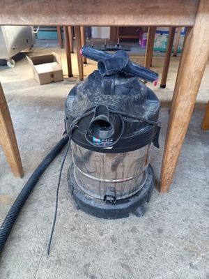 un aspirateur posé par terre, sous une table