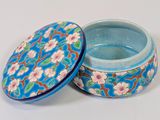 a blue box with flowers on it on a white surface