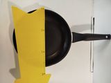 a black fry pan with a yellow arrow on it